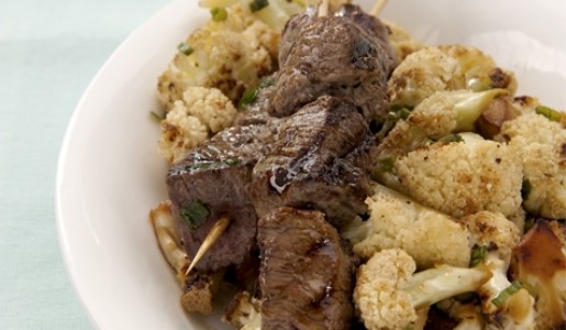 Brochetas de carne con coliflor salteada