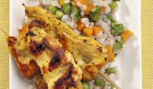 Brochetas de pollo al curry con pilaf de cebada.
